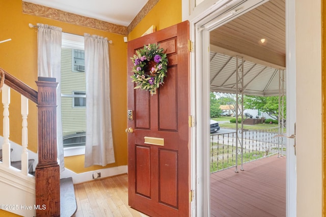entrance foyer featuring light wood finished floors, stairs, and baseboards