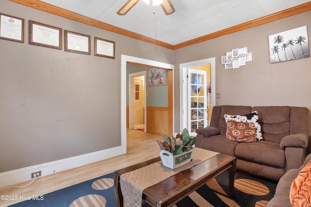 living room with wood finished floors, a ceiling fan, and crown molding