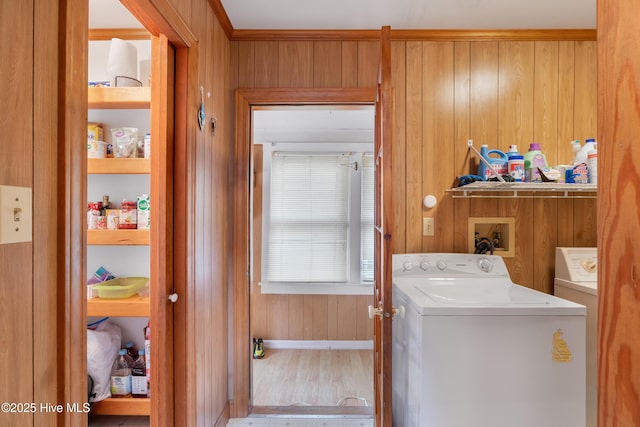 washroom with wood finished floors, wooden walls, laundry area, and washing machine and dryer