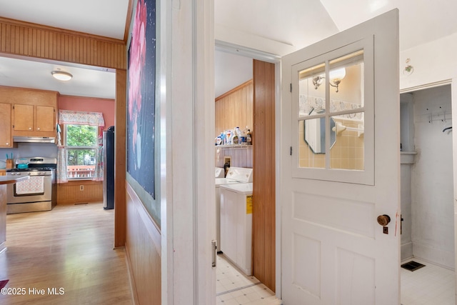 hall with light floors and separate washer and dryer