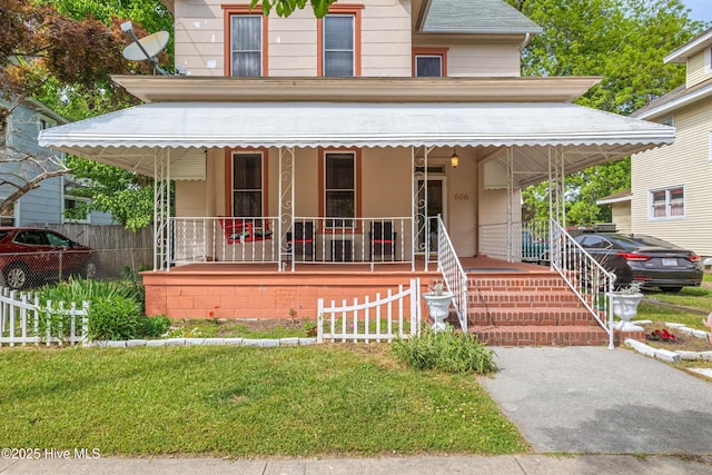 view of front of home featuring covered porch and fence
