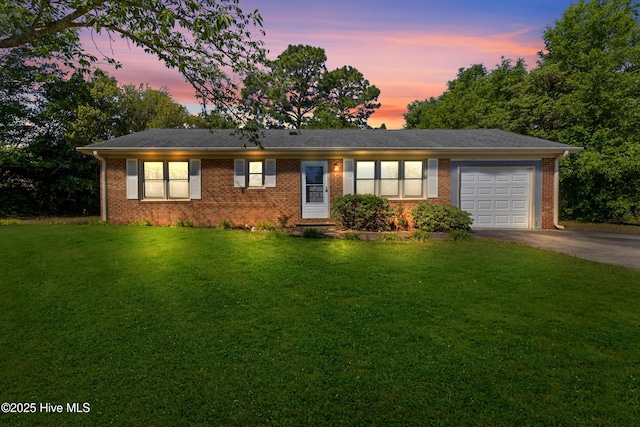 ranch-style house with brick siding, a garage, driveway, and a front yard