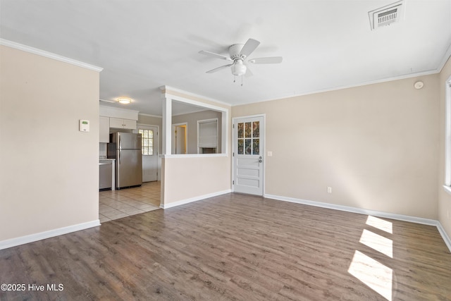 unfurnished living room featuring ceiling fan, visible vents, ornamental molding, and baseboards