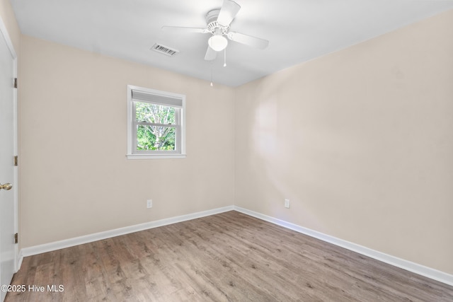 unfurnished room with baseboards, ceiling fan, wood finished floors, and visible vents