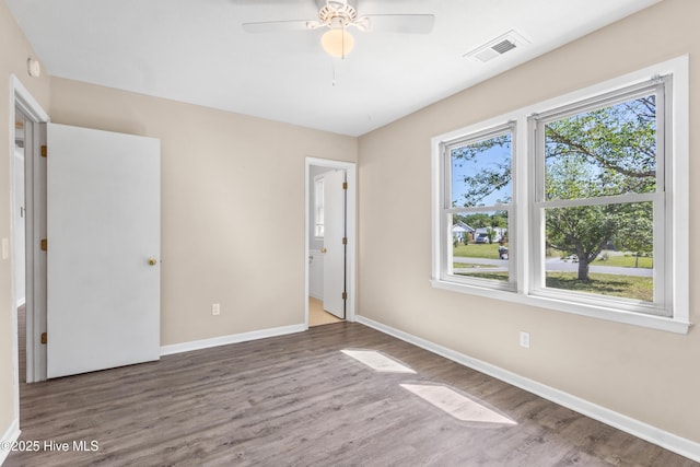 unfurnished bedroom featuring baseboards, visible vents, and wood finished floors