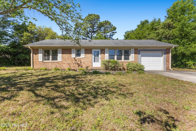ranch-style home featuring concrete driveway, brick siding, an attached garage, and a front yard