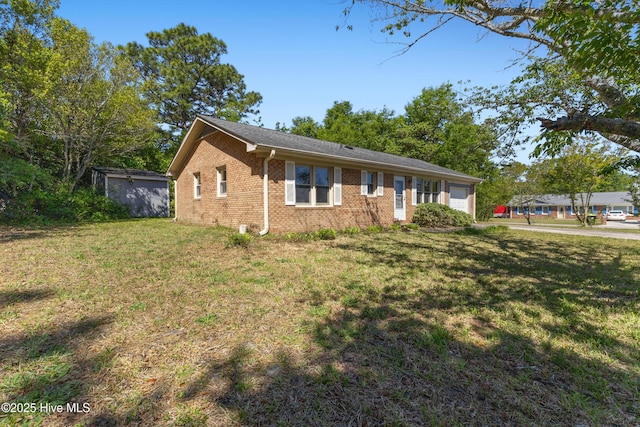 view of front facade with brick siding, a garage, and a front yard