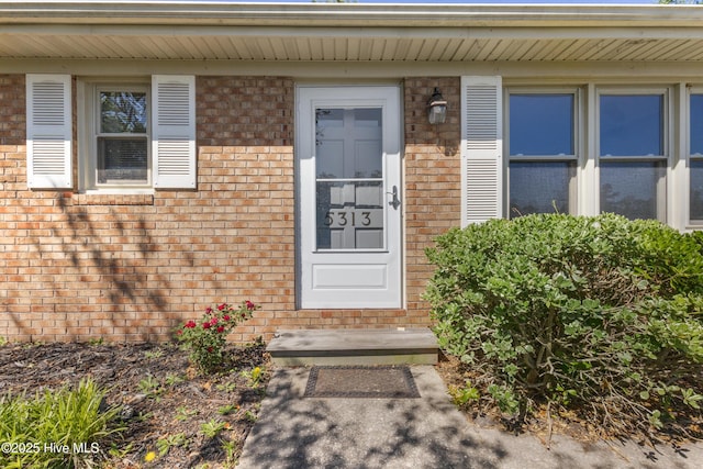 view of exterior entry with brick siding