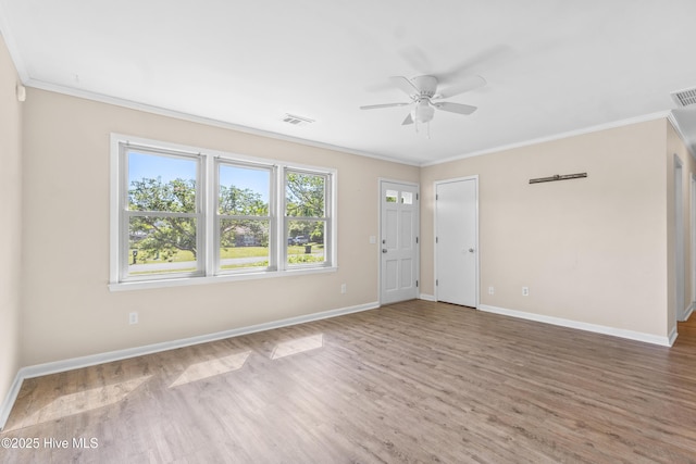 unfurnished living room with a ceiling fan, visible vents, ornamental molding, and wood finished floors