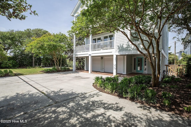 768 S Lumina Ave, Wrightsville Beach, NC 28480 - view of front of home featuring concrete driveway, an attached garage, and a balcony