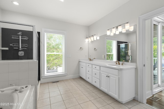768 S Lumina Ave, Wrightsville Beach, NC 28480 - full bathroom with double vanity, healthy amount of natural light, a shower stall, and a garden tub