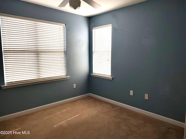 carpeted empty room featuring baseboards and ceiling fan