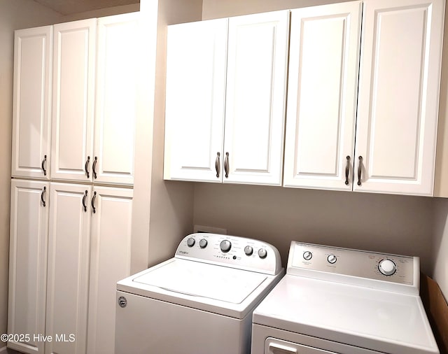 clothes washing area featuring cabinet space and washer and dryer