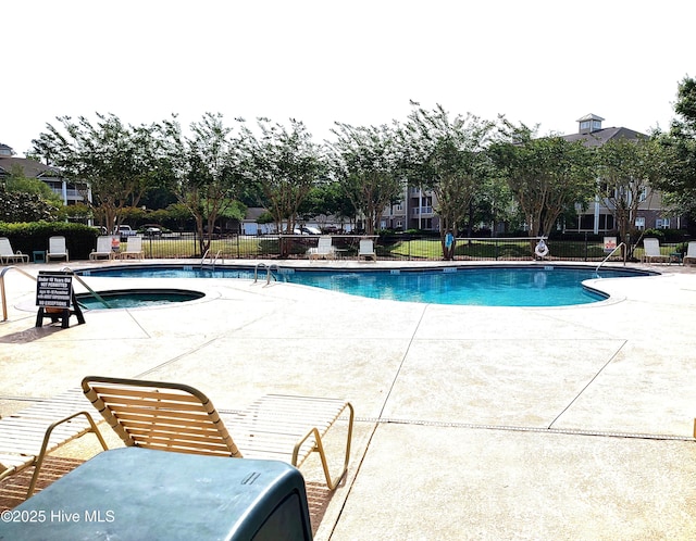 community pool with fence and a patio area