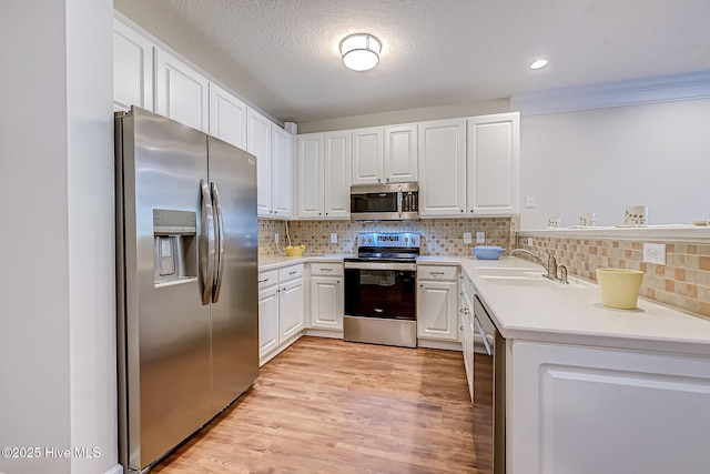 290 Woodlands Way Unit 10, Calabash, NC 28467 - kitchen featuring stainless steel appliances, a sink, light countertops, white cabinets, and tasteful backsplash