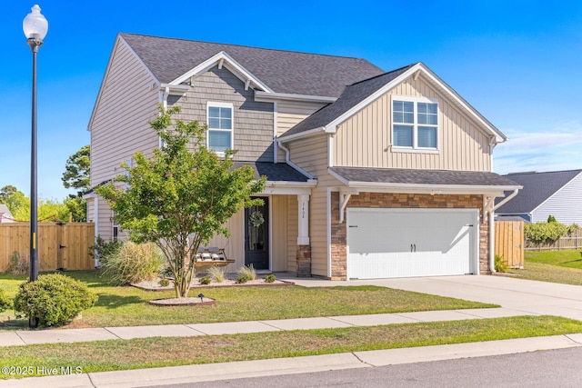 craftsman house with a front lawn, fence, board and batten siding, concrete driveway, and an attached garage