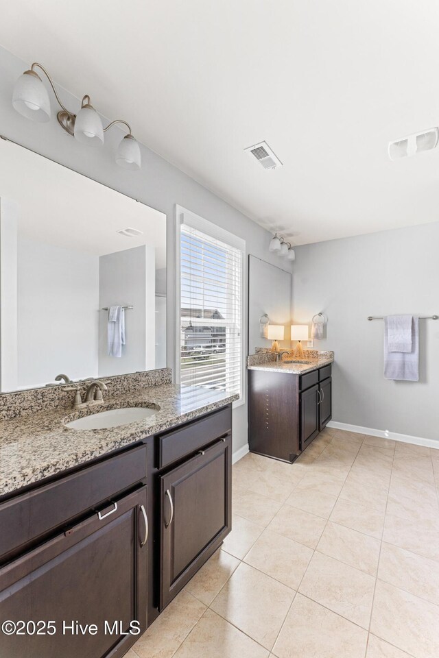 7408 Darius Dr, Wilmington, NC 28411 - bathroom with two vanities, baseboards, and tile patterned flooring