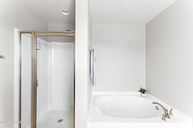 full bathroom featuring a stall shower and a bath