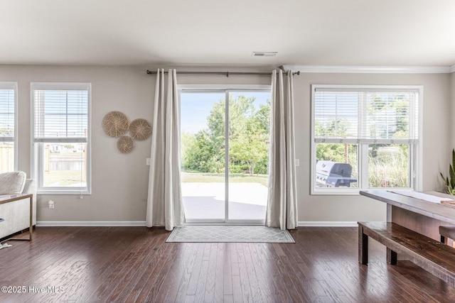 doorway featuring baseboards, plenty of natural light, dark wood-style floors, and visible vents