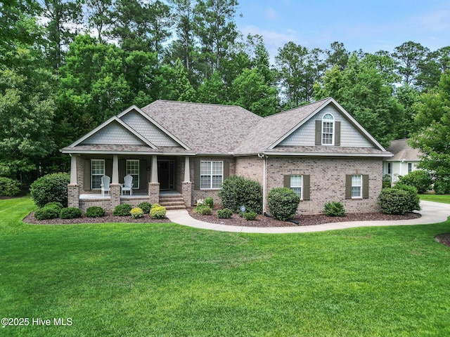 3603 Seafoam Ct, New Bern, NC 28562 - craftsman-style home with covered porch, brick siding, a front yard, and roof with shingles