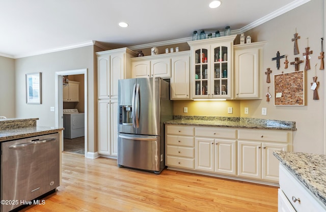 3603 Seafoam Ct, New Bern, NC 28562 - kitchen with stainless steel appliances, light wood-style floors, glass insert cabinets, crown molding, and separate washer and dryer