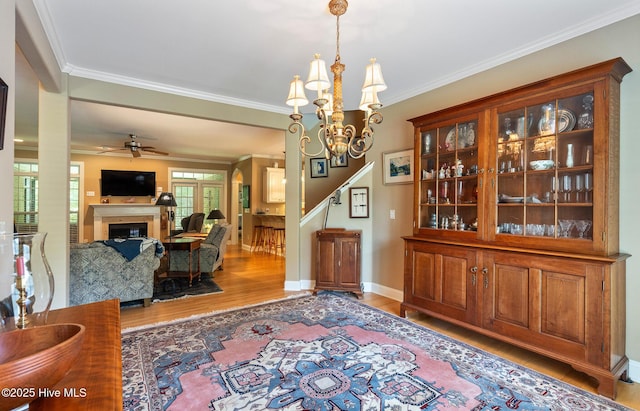 3603 Seafoam Ct, New Bern, NC 28562 - dining room featuring wood finished floors, a fireplace, ceiling fan, ornamental molding, and a chandelier
