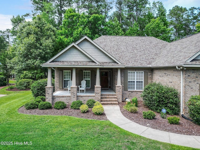 3603 Seafoam Ct, New Bern, NC 28562 - view of front of home featuring a porch, a front lawn, brick siding, and roof with shingles