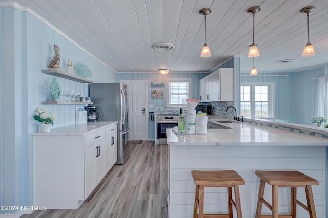 kitchen with crown molding, open shelves, a sink, stainless steel appliances, and a peninsula