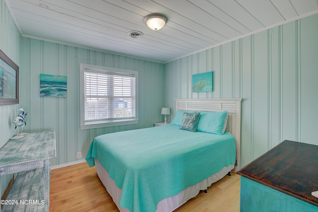 bedroom featuring crown molding, wood ceiling, visible vents, and light wood-type flooring