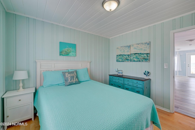 bedroom with light wood-style floors and crown molding