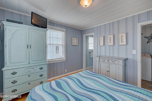 bedroom featuring crown molding, washer / clothes dryer, and baseboards