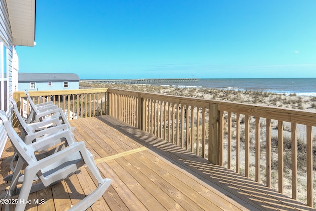 wooden deck with a view of the beach and a water view