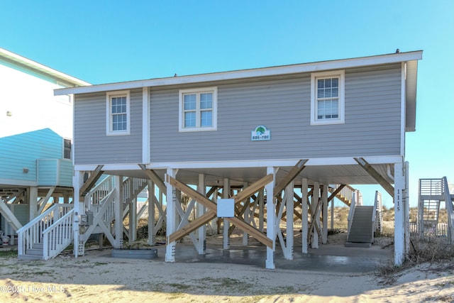rear view of house with stairway and a carport