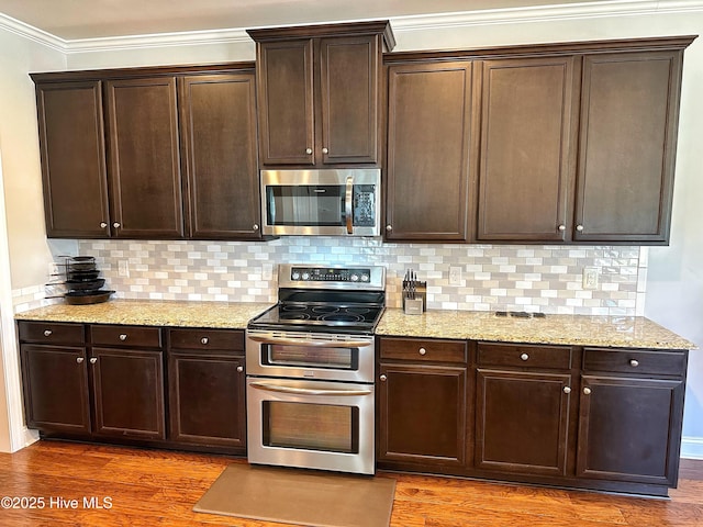 204 Liana Pl, Hubert, NC 28539 - kitchen featuring appliances with stainless steel finishes, wood finished floors, crown molding, dark brown cabinets, and decorative backsplash