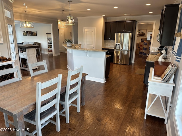 204 Liana Pl, Hubert, NC 28539 - kitchen featuring stainless steel fridge with ice dispenser, crown molding, decorative backsplash, light stone countertops, and a breakfast bar
