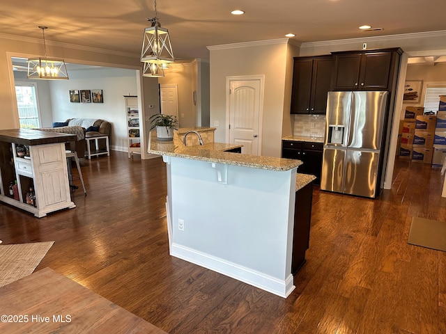 204 Liana Pl, Hubert, NC 28539 - kitchen with stainless steel fridge with ice dispenser, an island with sink, a kitchen breakfast bar, ornamental molding, and dark brown cabinetry