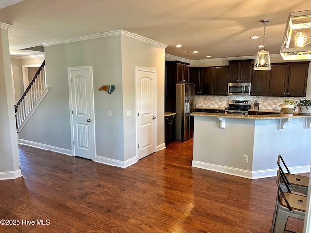 204 Liana Pl, Hubert, NC 28539 - kitchen featuring appliances with stainless steel finishes, a breakfast bar area, light stone counters, dark brown cabinets, and crown molding