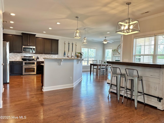 204 Liana Pl, Hubert, NC 28539 - kitchen with appliances with stainless steel finishes, a kitchen breakfast bar, recessed lighting, ceiling fan, and tasteful backsplash