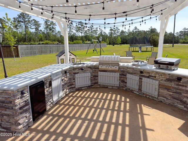 204 Liana Pl, Hubert, NC 28539 - view of patio / terrace featuring an outdoor kitchen, a grill, a trampoline, a playground, and view of scattered trees
