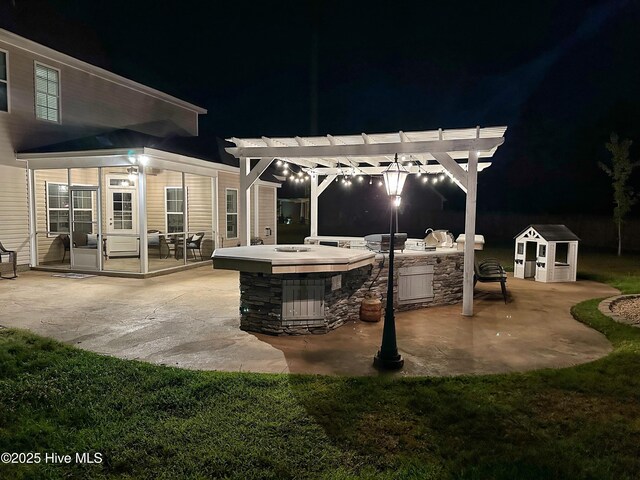 204 Liana Pl, Hubert, NC 28539 - patio at night featuring an outdoor kitchen, a pergola, and a yard