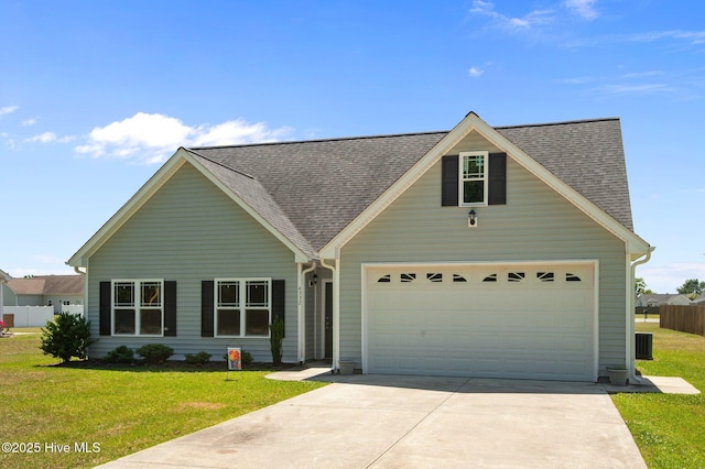 traditional-style home with roof with shingles, driveway, and a front lawn