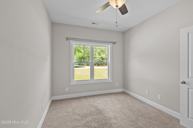 empty room with carpet flooring, ceiling fan, visible vents, and baseboards