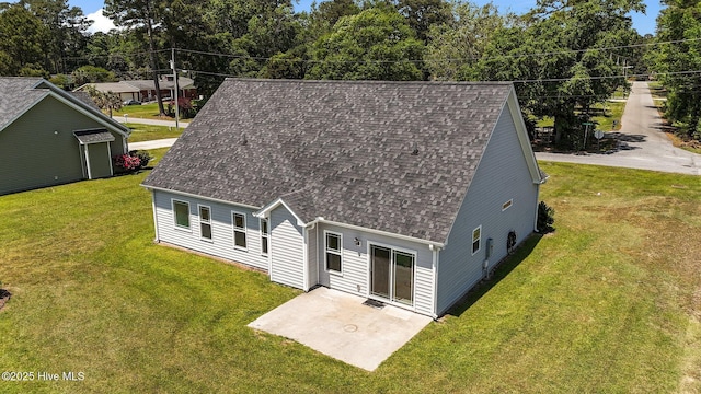 cape cod home featuring roof with shingles, a patio area, and a front yard