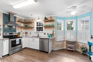 124 NE 15th St, Oak Island, NC 28465 - kitchen with a sink, wall chimney range hood, open shelves, a ceiling fan, and appliances with stainless steel finishes
