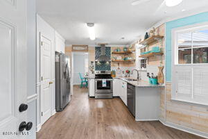 124 NE 15th St, Oak Island, NC 28465 - kitchen with dark wood-style flooring, open shelves, appliances with stainless steel finishes, and a sink