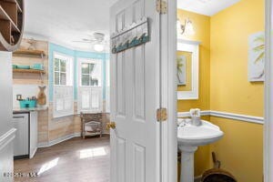 124 NE 15th St, Oak Island, NC 28465 - bathroom with baseboards, ceiling fan, and wood finished floors