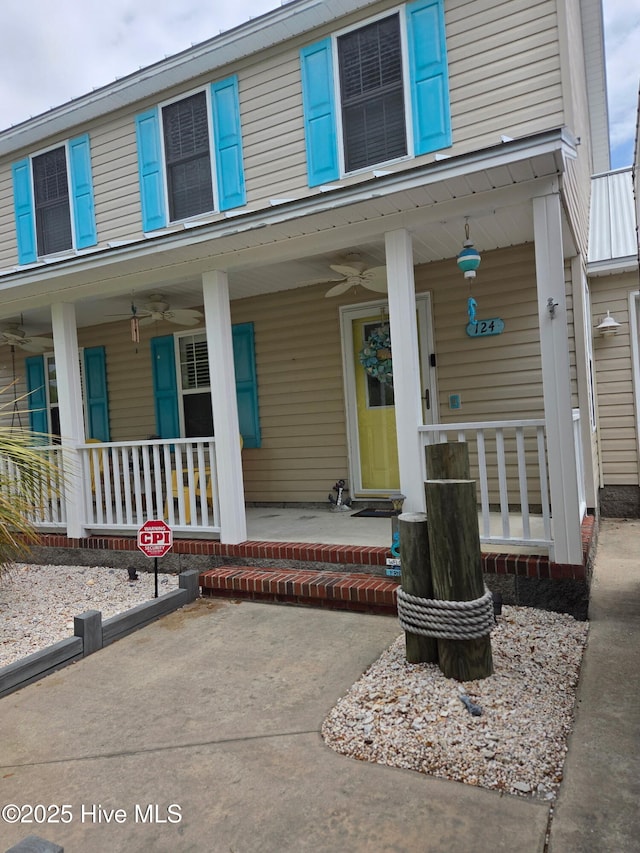 entrance to property with a ceiling fan and a porch