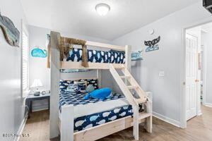124 NE 15th St, Oak Island, NC 28465 - bedroom with baseboards and wood finished floors