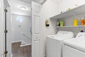 124 NE 15th St, Oak Island, NC 28465 - clothes washing area with washing machine and dryer, laundry area, baseboards, and wood finished floors