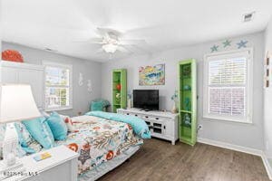 124 NE 15th St, Oak Island, NC 28465 - bedroom with baseboards, multiple windows, a ceiling fan, and wood finished floors